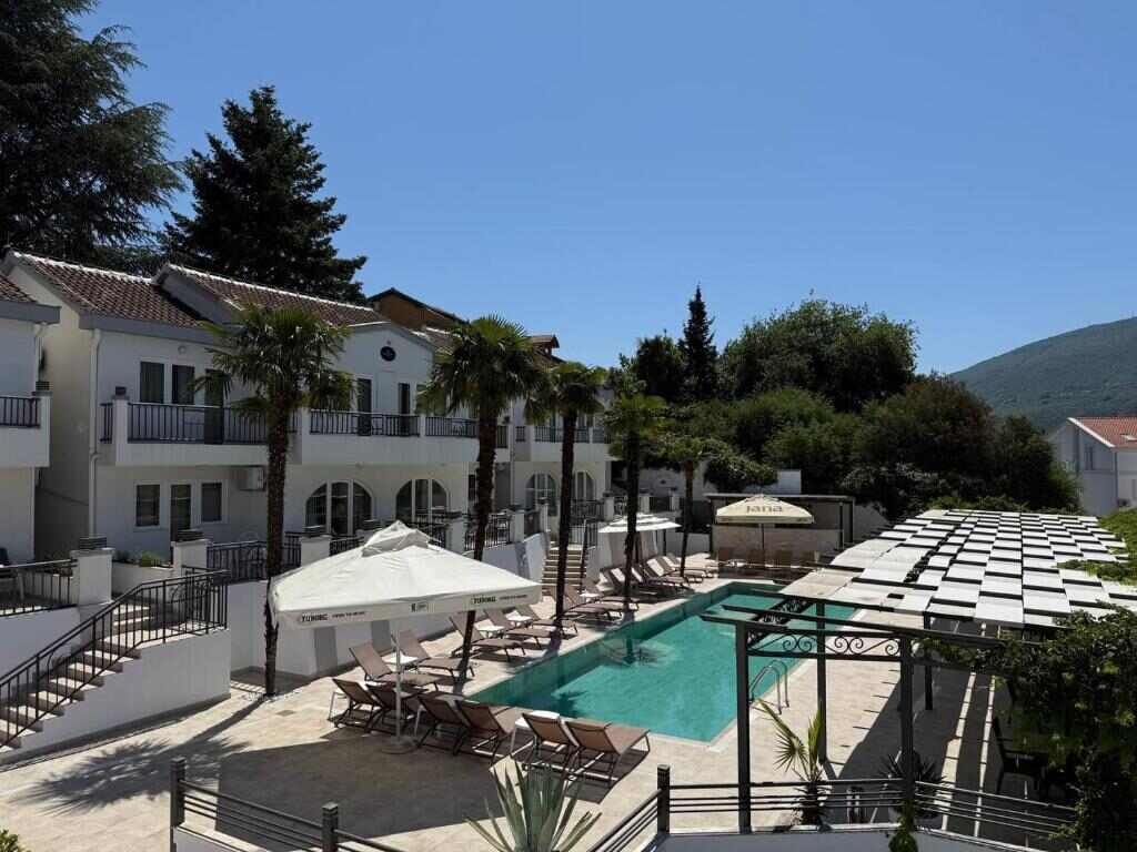 View over the pool terrace and hotel building towards the hills
